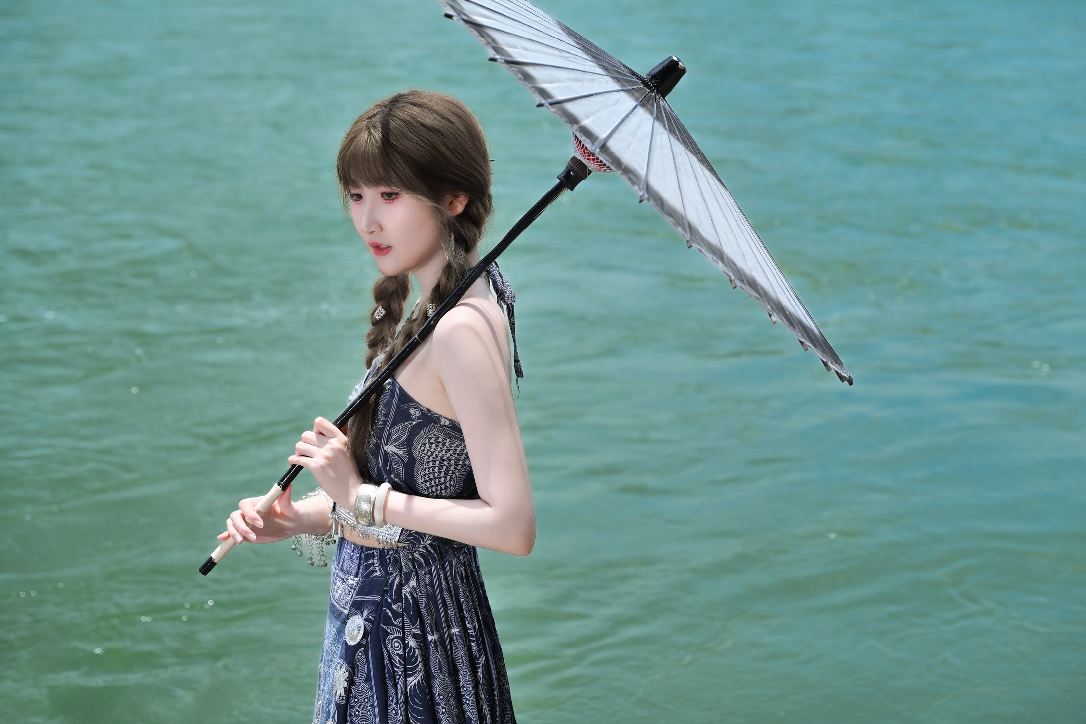Cici holding an umbrella beside the river