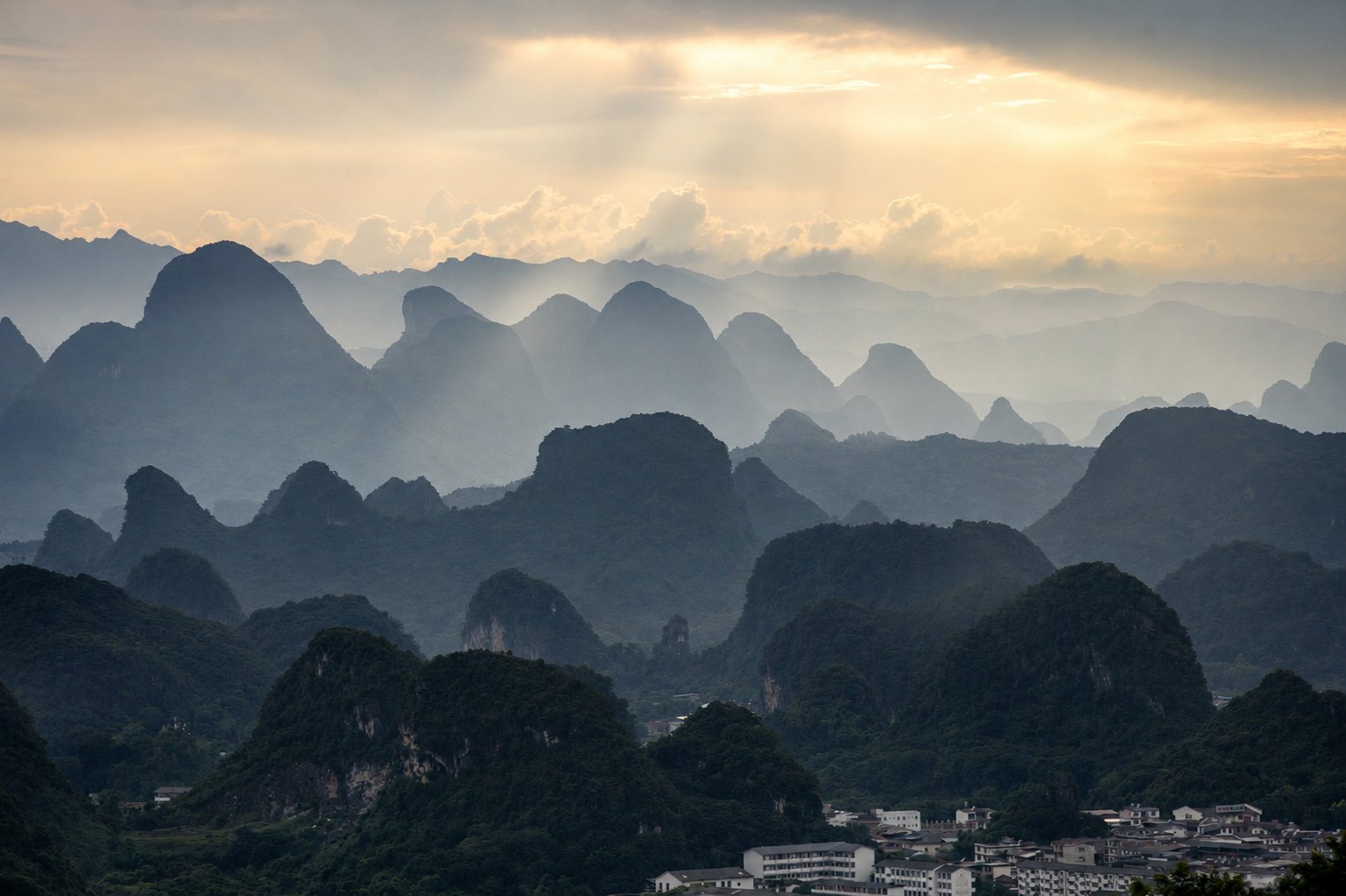 Golden light over layered karst mountains in Guilin