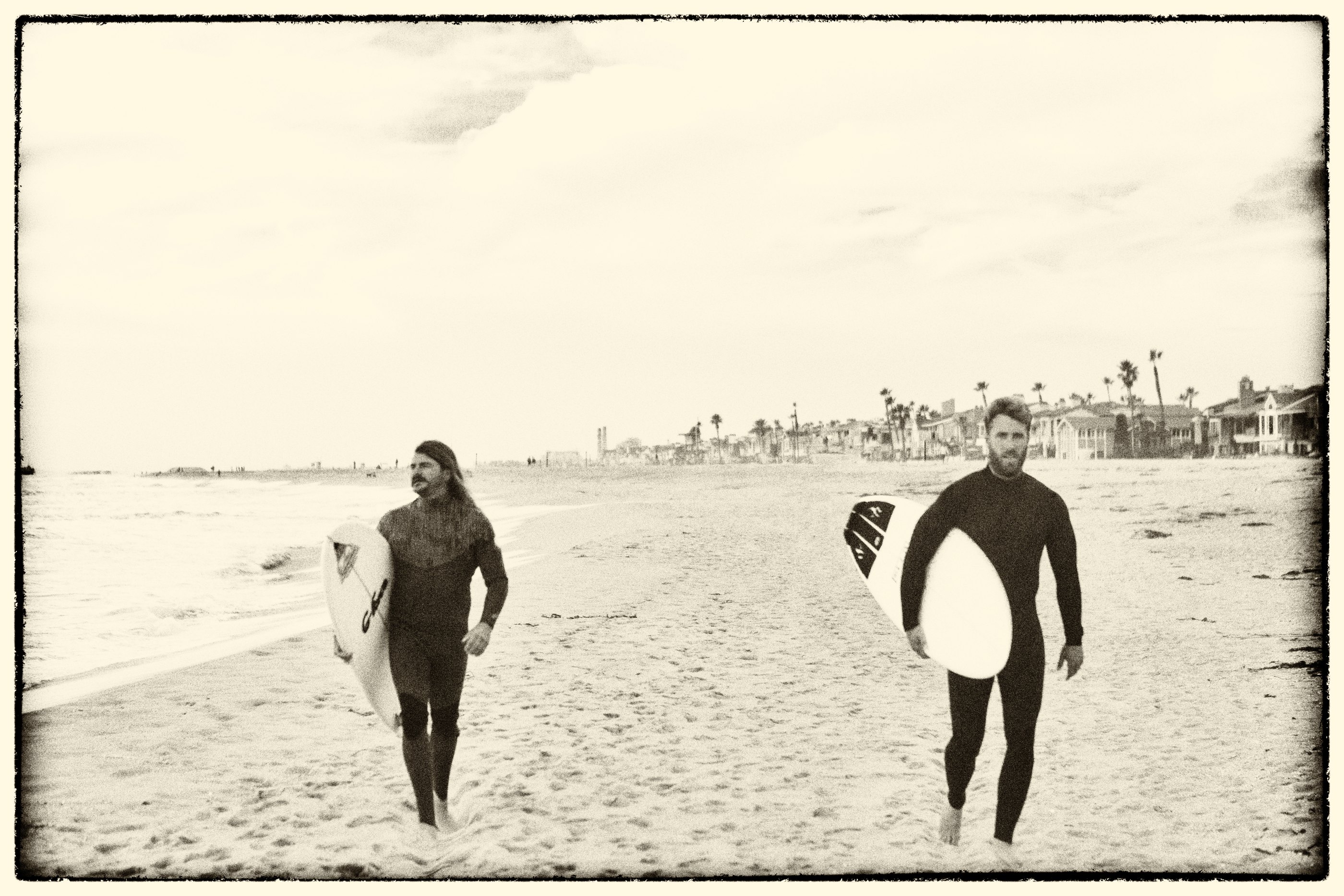 Surfers walking along a Southern California beach